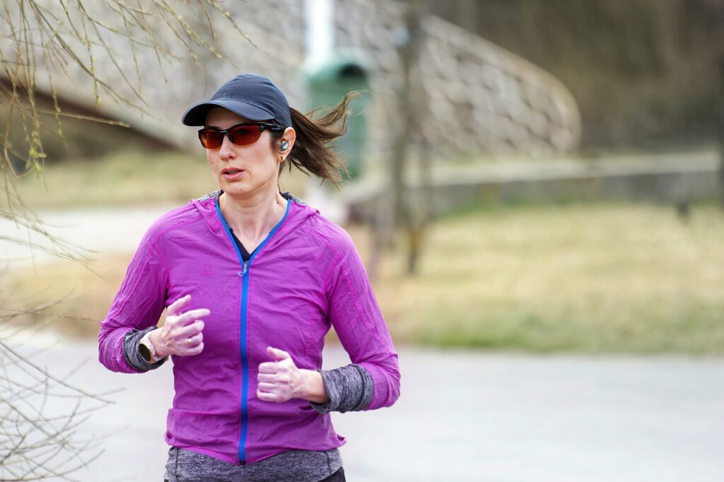 Woman jogging wearing smart watch and bluetooth ear phones